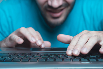 Smiling laptop user. Typing on keyboard.