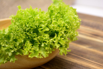 Fresh organic green lettuce salad leaves in wooden bowl Healthy food concept