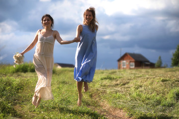 Fototapeta premium Young girls are walking in the field