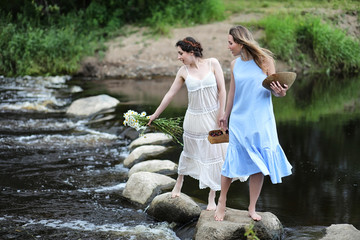 Beautiful girls in dresses on the river