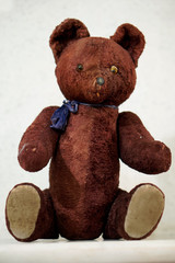 Old toy - a vintage plush brown bear sits on the mantel