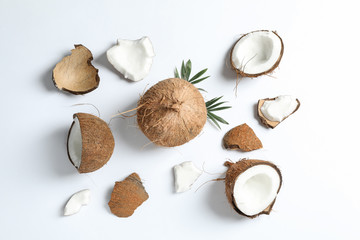 Flat lay composition with split coconut and its pieces on white background