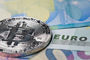 Bitcoin, close-up. Cryptocurrency. Euro banknotes background