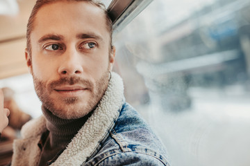 Hipster young male going in bus near window