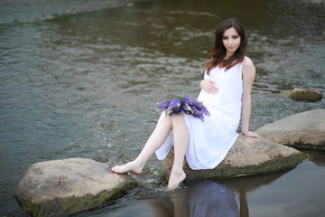 Pregnant woman in nature for a walk in the summer