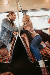 Happy beloved couple in retro bus cafe