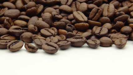 Close up of roasted coffee beans on white background