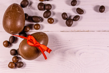 Chocolate easter eggs on a white wooden table. Top view