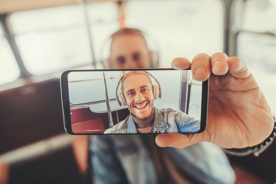 Portrait of happy man in headphones in smartphone