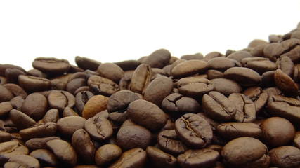 Close up of roasted coffee beans on white background