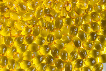 yellow capsules pills close-up. vitamin e, d, fish oil. top view