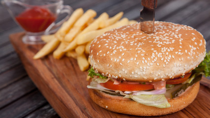 Fast food, delicious burger, beautifully laid out on a wooden background, for culinary design