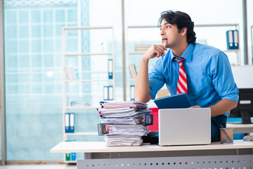 Handsome businessman unhappy with excessive work in the office 