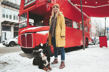 Smiling pretty woman staying with her dog outdoor