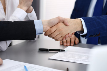 Business people shaking hands, finishing up a papers signing. Meeting, agreement and lawyer consulting concept