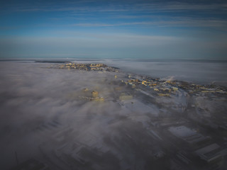 thick fog over the city in the rays of the rising sun