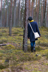 Lonely Girl stands at the tree in the forest. Solitude