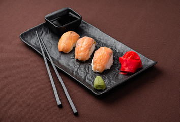 sushi with salmon on a black plate