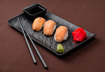sushi with salmon on a black plate