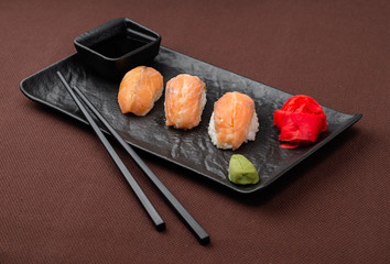 sushi with salmon on a black plate