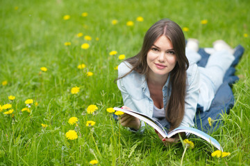 Woman lying on grass with magazine