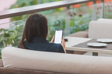 woman with phone sitting in cafe