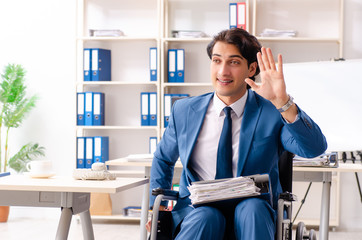 Male employee in wheelchair working at the office 