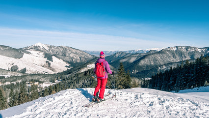 Women skier finding the best track. Skier looking down to the valley. Waiting for right moment. Best choice. Chopok, Low Tatras, Slovakia.