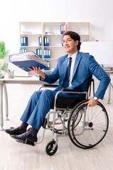 Male employee in wheelchair working at the office 