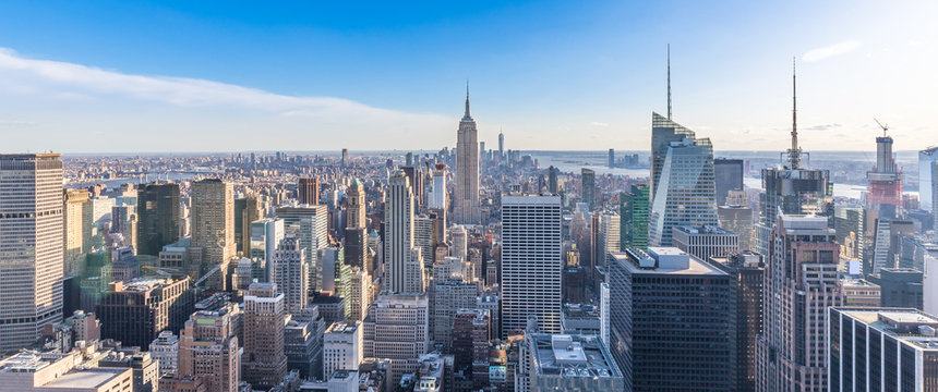 Panoramic photo of New York City Skyline in Manhattan downtown with Empire State Building and skyscrapers on sunny day with clear blue sky USA