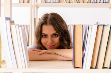Young female student preparing for exams at library 