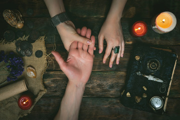 Palmistry concept. Fortune teller reading future on the hand on a magic table background. Future...