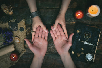 Palmistry concept. Fortune teller reading future on the hand on a magic table background. Future...