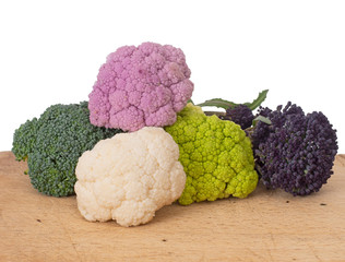 Colourful vegetables, white background. Assorted raw cauliflower, broccoli and purple sprouting florets. Healthy assortment.