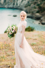 Fototapeta na wymiar Stunning bride in beautiful wedding dress on natural background.