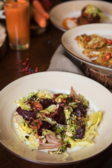 Healthy vegeterian food on brown wood board. Spring vitamin dieting food. Salad from beet with dried tomatoes and cabbage