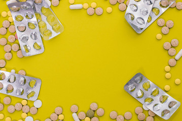 Medical colorful pills, capsules or supplements for the treatment and health care on yellow background. Creative idea. Drugs. Sad. Die. Illness.