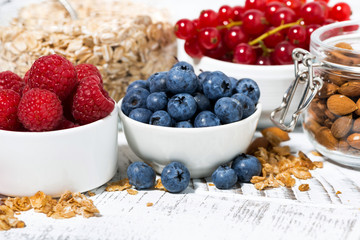 fresh blueberries, raspberries and breakfast products on white table, closeup