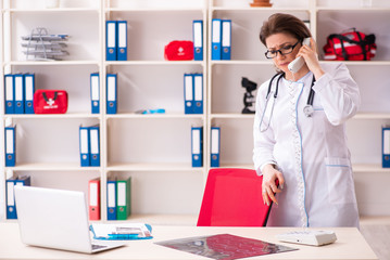 Aged female doctor working in the clinic 