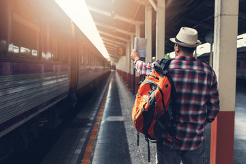 Asian traveler man with belongings waiting for travel by train