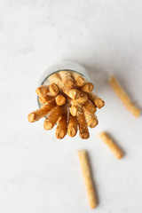 Italian grissini or salted bread sticks on a light stone background. Fresh italian snack. Copy space. 