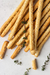 Italian grissini or salted bread sticks on a light stone background. Fresh italian snack. Copy space. 