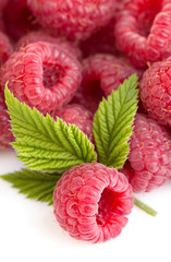 Ripe raspberries with leaves close-up as a background.