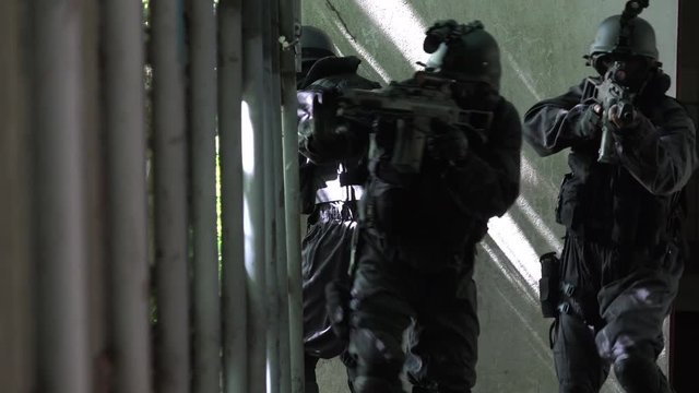 A Special Force Team walk in a open corridor.