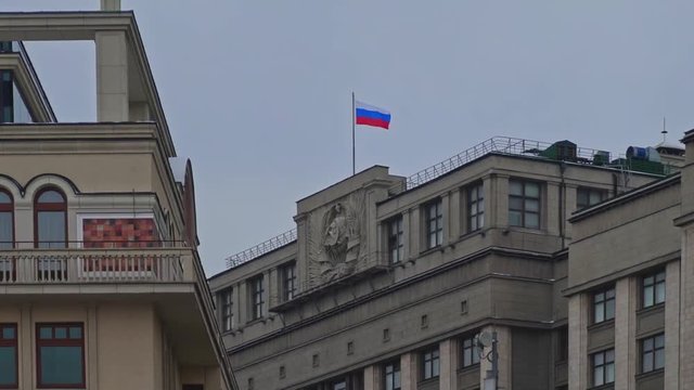 MOSCOW, RUSSIA - DECEMBER 6: Timelapse of state russian flag fluterring over the State Duma in Moscow. Handheld shoot slowmotion of the russian state flag fluttering over State Duma in windy weather