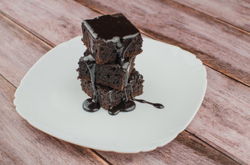 Sliced homemade brownies on white plate. Served on rectangle white plate. Favorite chocolate dessert for chocolate lover. Sweet and moist of cocoa taste. Top view.