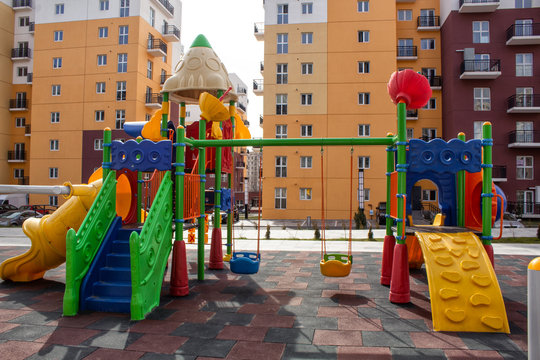 Children's playground with slides and swings in the courtyard of residential buildings.