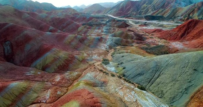 Flying drone through breath-taking rainbow mountains. Aerial 4k footage showing the most beautiful valley in Zhangye National Geopark. Zhangye Danxia in Gansu Province, China. 