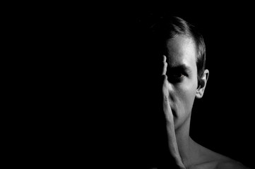 Dramatic portrait of a guy on a black background, black and white photography