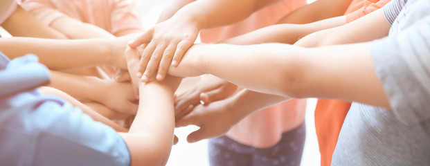 Little children putting their hands together, closeup. Unity concept